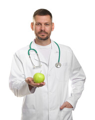 Nutritionist with green apple and stethoscope on white background