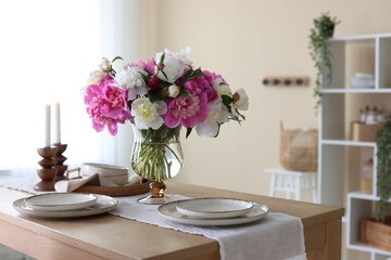 Beautiful table setting with bouquet of peonies in dining room