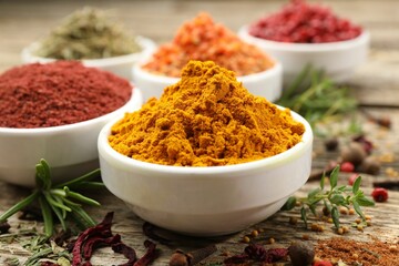 Different aromatic spices on wooden table, closeup