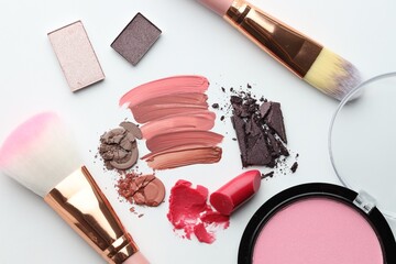 Different cosmetic products and makeup brushes on white background, flat lay