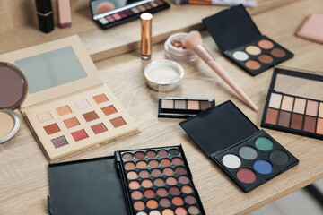 Different makeup products and brush on vanity indoors