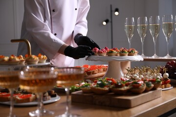 Chef arranging appetizers on buffet table, closeup
