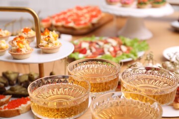 Buffet menu. Glasses of sparkling wine and tasty appetizers on table, closeup