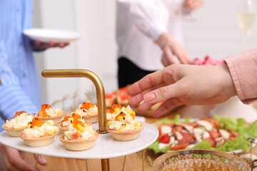 People with different appetizers at buffet, selective focus