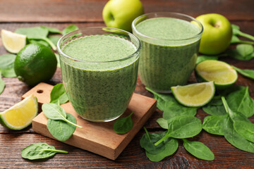 Tasty spinach smoothie and ingredients on wooden table, closeup