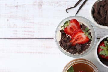 Tasty panna cotta with chocolate, strawberries, vanilla and caramel on white wooden table, flat...