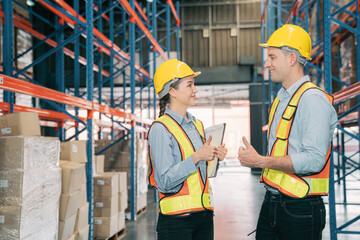 Confidence caucasian man, woman staff worker wear safety helmets, vest show teamwork collaborate, cooperation in logistics inventory operation. show success, efficiency in modern warehouse management.