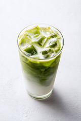 Matcha latte in clear glass with green gradient — refreshing iced beverage perfect for health and wellness visuals.