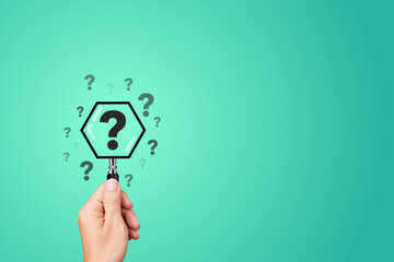 Hand Holding Magnifying Glass with Question Mark Icon on Blue Background - Concept of Problem...