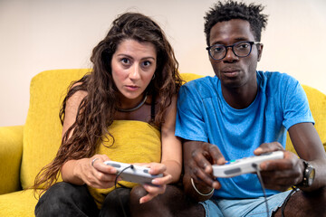 A focused and determined diverse couple looks directly at the camera, ready for a video game...