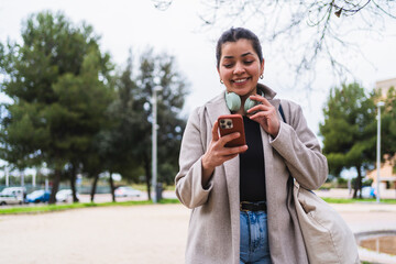 Young woman creating content for social media using a smartphone in a city park