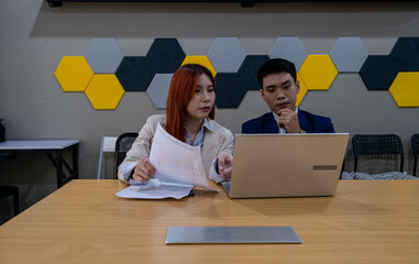 Team collaborates on project in modern workspace during afternoon meeting with focus on a laptop