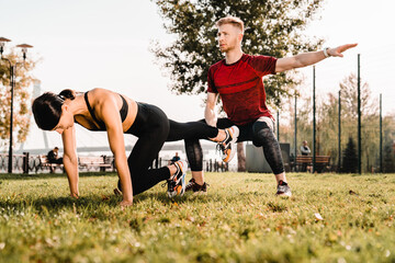 Two people training together outdoors gym, doing functional fitness exercises in a peaceful park. Concept of teamwork, healthy lifestyle, and outdoor workout in natural sunlight