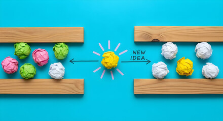 A bright yellow paper ball shines as a creative new idea moves from crumpled colored paper towards clean white paper on a blue background.