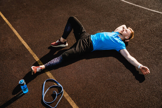 Fitness, tired and man with sweat in outdoor for running challenge, exhausted or marathon training. Breathing, sports and male athlete with break for workout fatigue, cardio exercise or resting