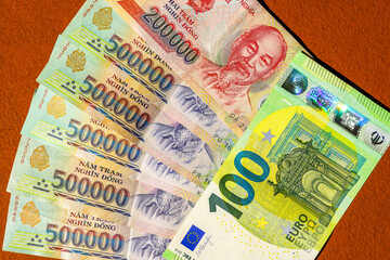 Equivalence of Vietnamese dong and Euro banknotes displayed together on a textured orange background