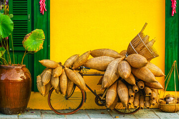 Traditional Bamboo Fish Traps on Bicycle Against Bright Yellow Wall in Vietnam Street Scene