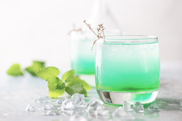 glass of cold drink with fresh mint leaves and ice cubes