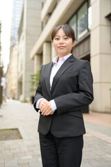 ビル街でカメラ目線で微笑む日本人女性