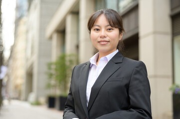 ビル街でカメラ目線で微笑む日本人女性