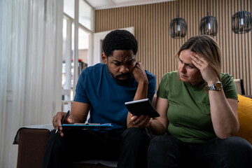 Worried Interracial Couple Struggling with Financial Problems at Home, Concerned About Rent Prices, Living Costs, Inflation, Interest Rates and Bills