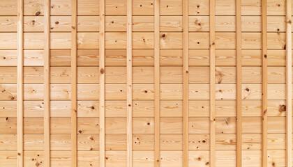 Close-up of wooden wall is composed of laid wooden planks, laid neatly next to each other, each with a visible grain pattern