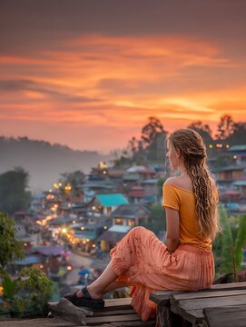A young woman sitting on the mountain at sunset with a beautiful city view, Switzerland, girl, 