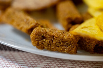  Fried rye bread croutons and potato chips served on white plate. Close up snack food photography. Beer snack and appetizer concept