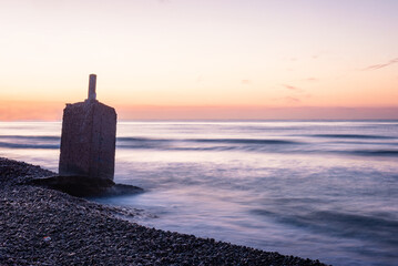 Sunrise Serenity: Tranquil Beachscape with Stone Monolith