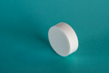 White medicine tablet standing on side on blue pastel background as macro 1