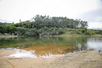 Foto de uma ponte cruzando uma represa em meio à natureza. As águas calmas refletem a estrutura e a vegetação ao redor, compondo uma cena tranquila e harmônica. Ideal para temas de infraestrutura, mei