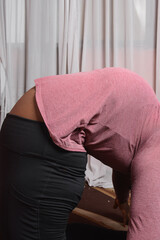 Plussize woman doing yoga stretches in her home, brown skin woman stretching to keep fit