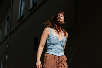 Young caucasian female in sunlight with flowing hair and casual attire