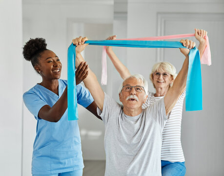 Doctor or nurse or physiotherapist caregiver exercise with senior man and woman couple  at clinic or nursing home - Powered by Adobe