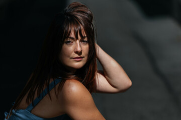 Naklejka premium Young caucasian female posing outdoors with sunlit hair