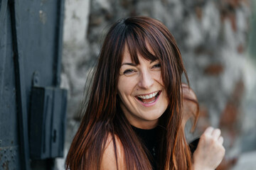 Smiling young caucasian female with long brown hair outdoors