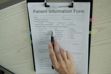 Young asian woman doctor in white uniform with stethoscope taking notes, using laptop, mobile phone, writing in medical journal, professional therapist practitioner filling documents or patient card.