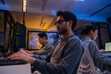 Young Asian business people working late into the night in the office, meeting, brainstorming,...