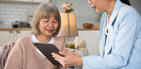 Asian elderly woman consulting with a doctor at home or in a nursing care setting. Medical discussion, healthcare insurance, expert advice, diagnosis support, and senior care service.