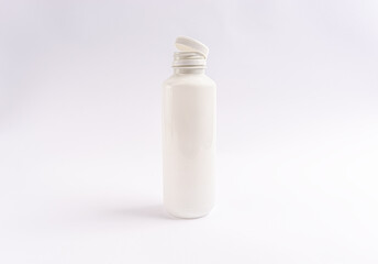 white plastic bottle with open lid on white background