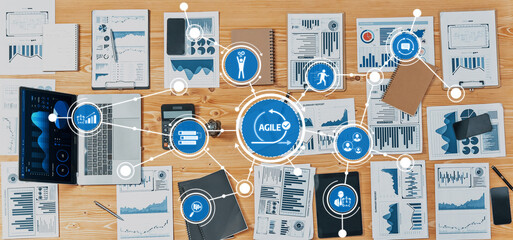A top-down view of a desk filled with analytics reports, charts, and data visualization tools, showcasing a dynamic workspace for agile business strategies and collaboration. Amity