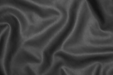 Fototapeta premium Close-up of smooth black leather texture highlighting soft folds and natural sheen.