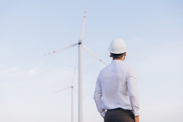 Engineer looking at wind turbines in a wind farm
