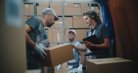 Multiethnic Workers Unloading Cardboard Boxes with Online Orders, E-Commerce Goods from Delivery Truck. Female Manager Using Tablet Computer and Barcode Scanner. Outside of Logistics Retail Warehouse.