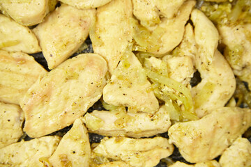 Sliced cooked chicken breast pieces seasoned with spices, resting on a black skillet, showcasing a delicious and appetizing meal preparation for culinary enthusiasts and food lovers