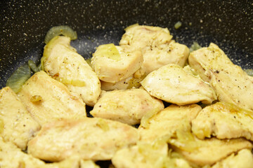 Sauteed chicken breast pieces seasoned with spices and cooked in a frying pan, surrounded by...