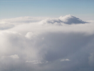Expansive view of soft, fluffy clouds against a clear blue sky, creating a serene atmosphere, ideal for backgrounds or nature-themed projects with copy space