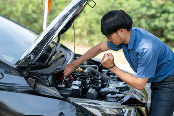 Mechanic or driver providing roadside assistance by changing a flat tire and performing minor...