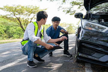 Mechanic or driver providing roadside assistance by changing a flat tire and performing minor...