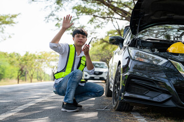 Mechanic or driver providing roadside assistance by changing a flat tire and performing minor...
